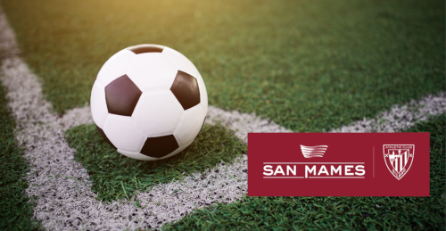 imagen de un balón de fútbol sobre el césped de un campo de fútbol junto a la imagen corporativa oficial del estadio de San Mamés